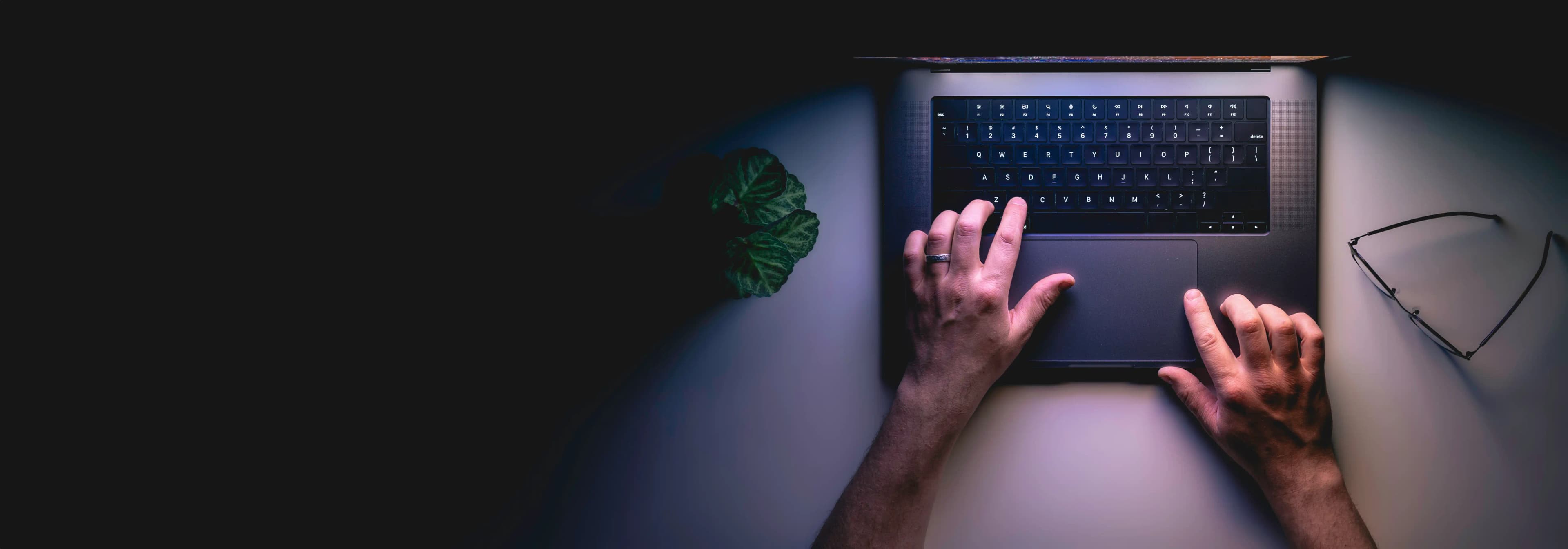 Hands working on a laptop at a desk